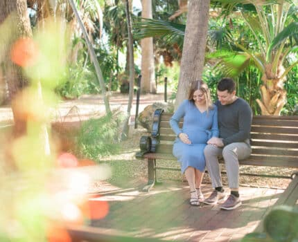 Husband and wife reveling over babies in park in St. Pete Maternity Session